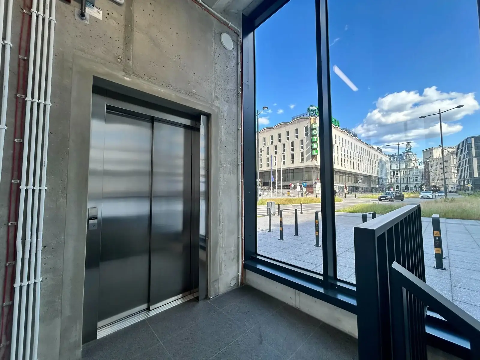 Parking Plac Powstańców Warszawy - winda i hol wejściowy z widokiem na Hotel Warszawa i centrum Warszawy