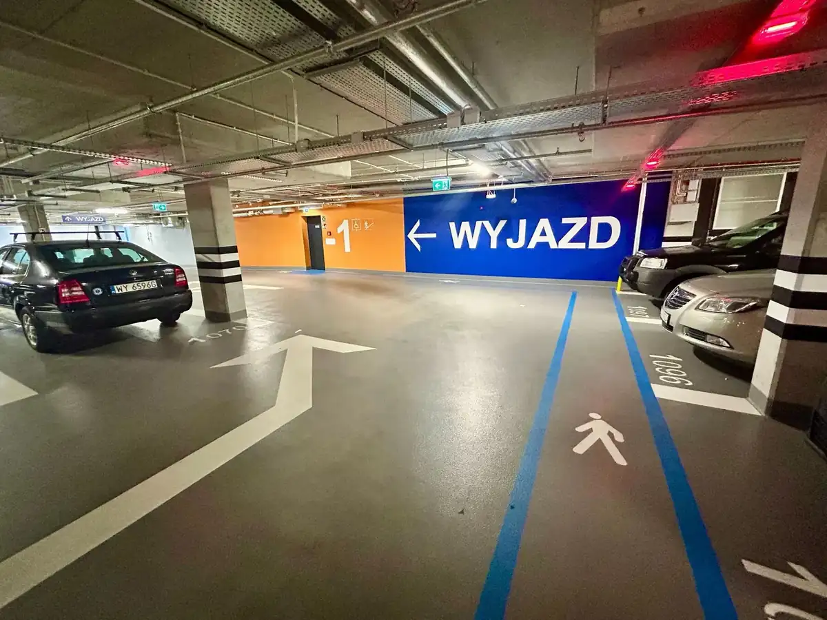 Parking Plac Powstańców Warszawy - wnętrze parkingu podziemnego, przestronne i czyste, szerokie pasy jezdne